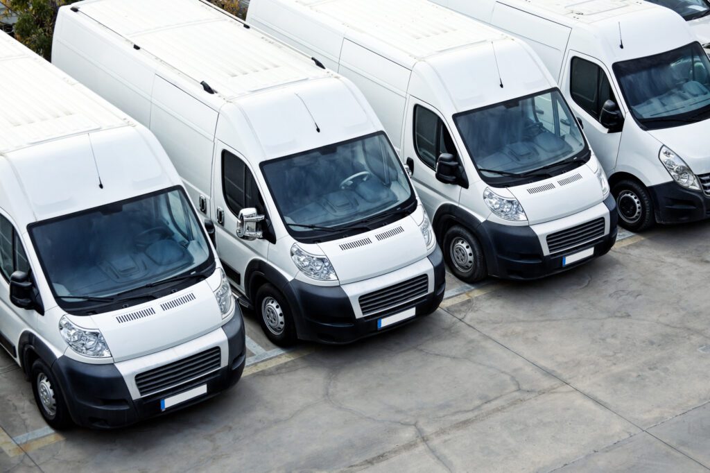 Row of white vans parked beside each other on the about page.