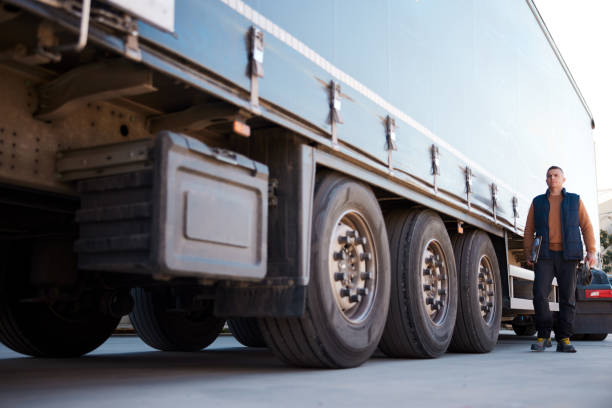 Mid adult trucker driver walking toward the cabin of his semi-truck. Full length with copy space