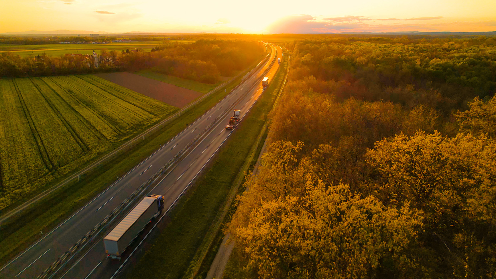 Truck driving on the motorway into the sunset.