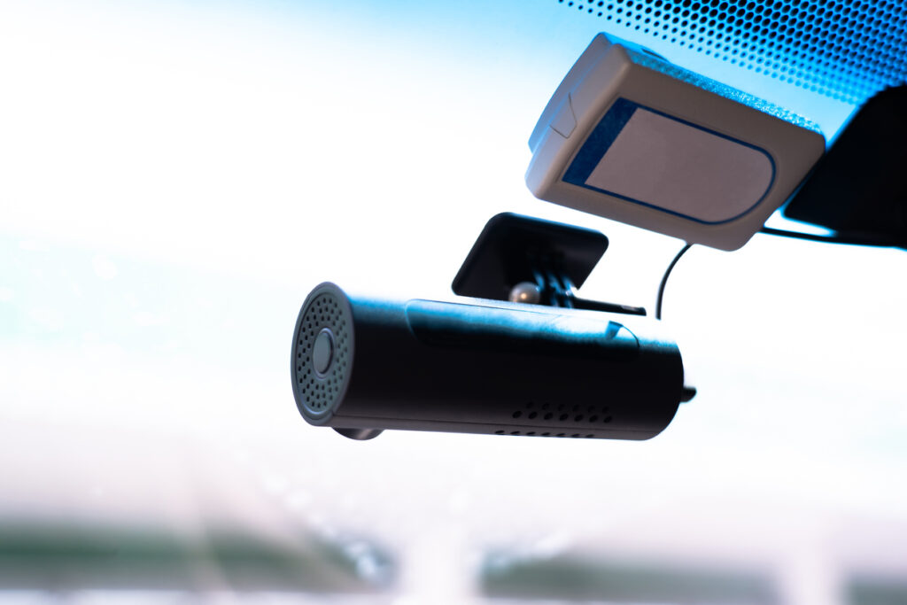 A small video camera records events. Attached to the windshield. Video monitoring concept for human driving safety