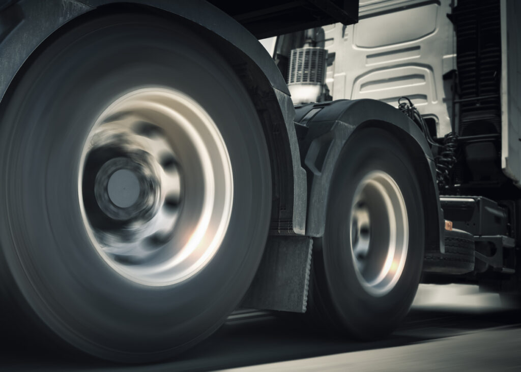 Fast Spinning Wheels. Semi Trucks Driving on the Road. Diesel Truck. Freight Truck Logistics Cargo Transport Concept.