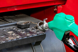 Diesel fuel nozzle fueling semi tractor, grain truck. Fuel price increase, renewable diesel, farming, and transportation concept