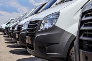 number of new white minibuses and vans outside