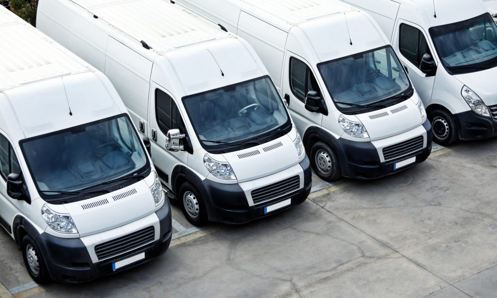 Row of white vans parked beside each other on the about page.