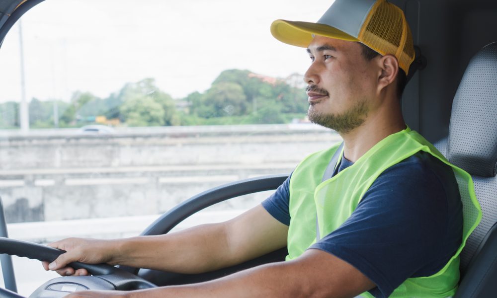 Professional worker truck driver, confident middle-aged Asian man wearing safety clothing Smile proudly In moving forward For a long transportation business